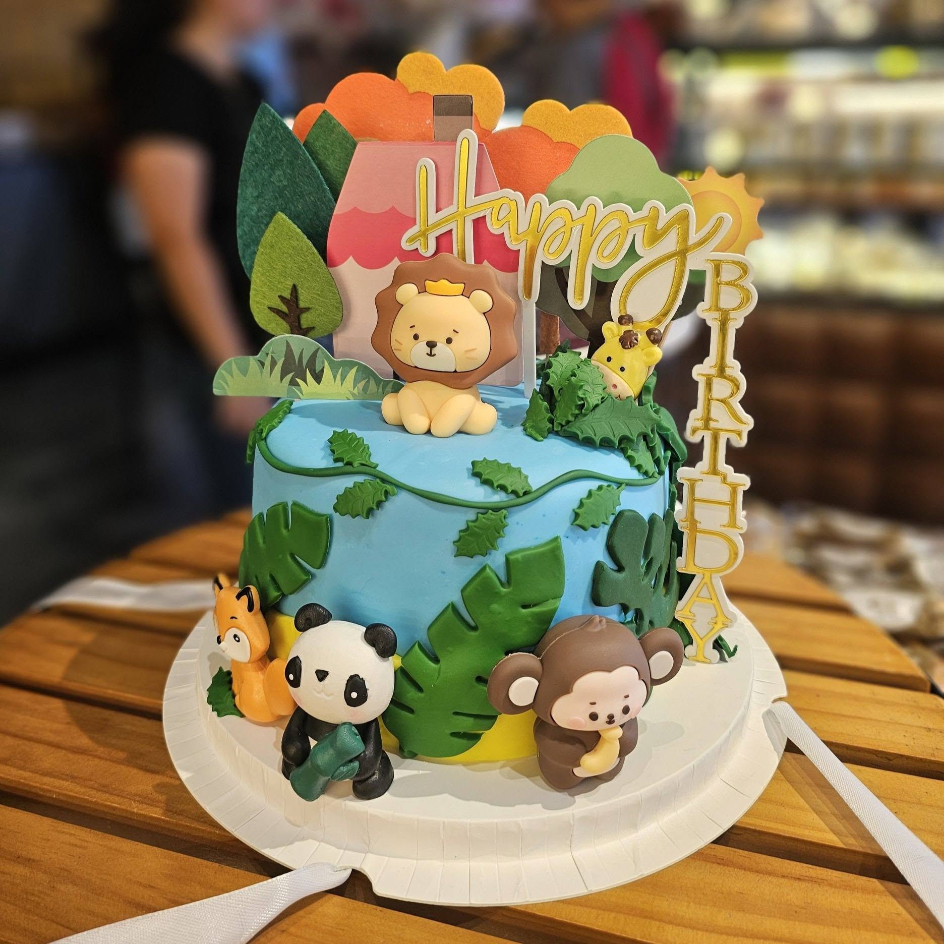 Custom decorated cake with jungle theme toppers