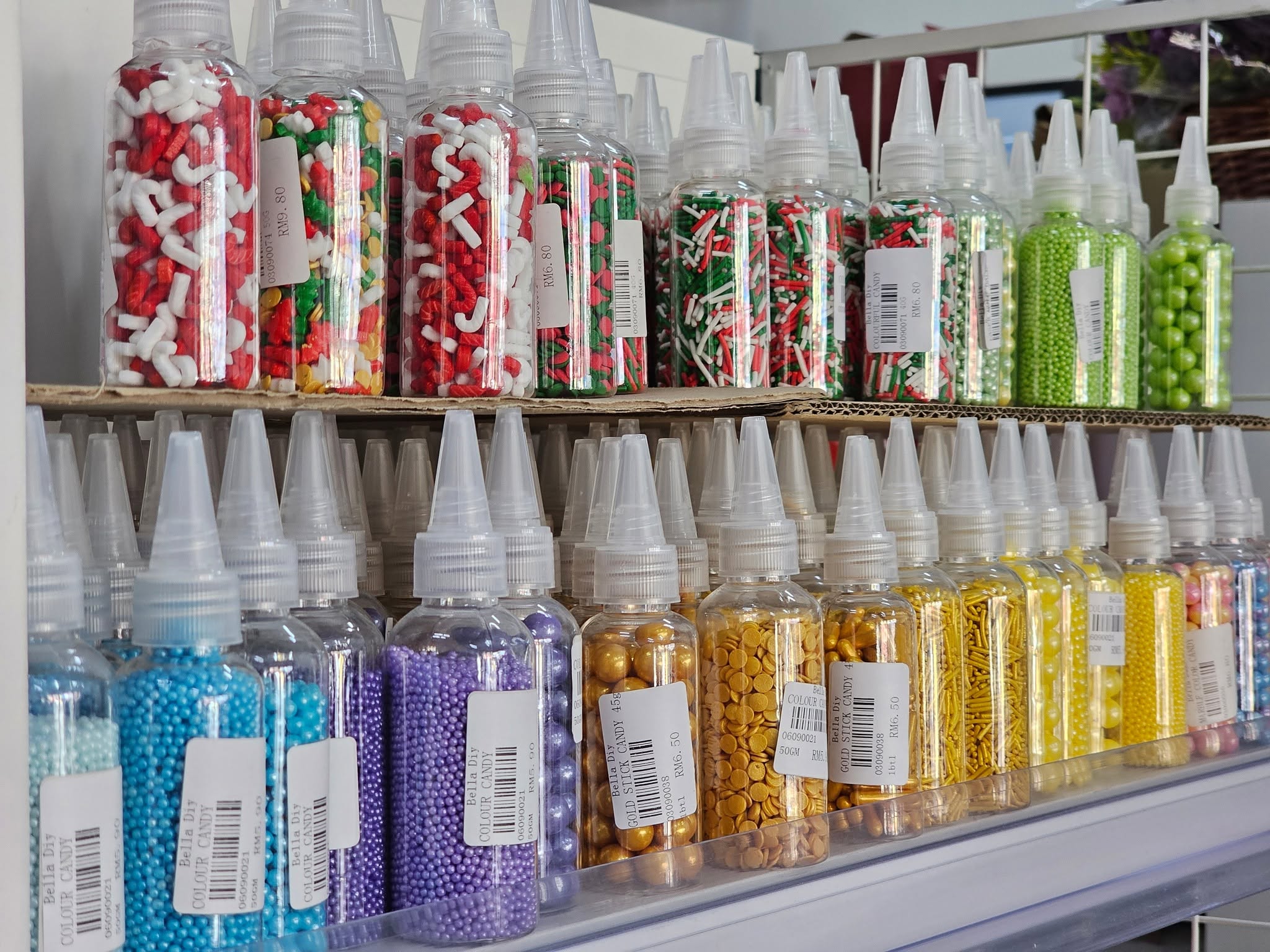 Shop shelves lined with bottles of colourful sprinkles and candy decorations