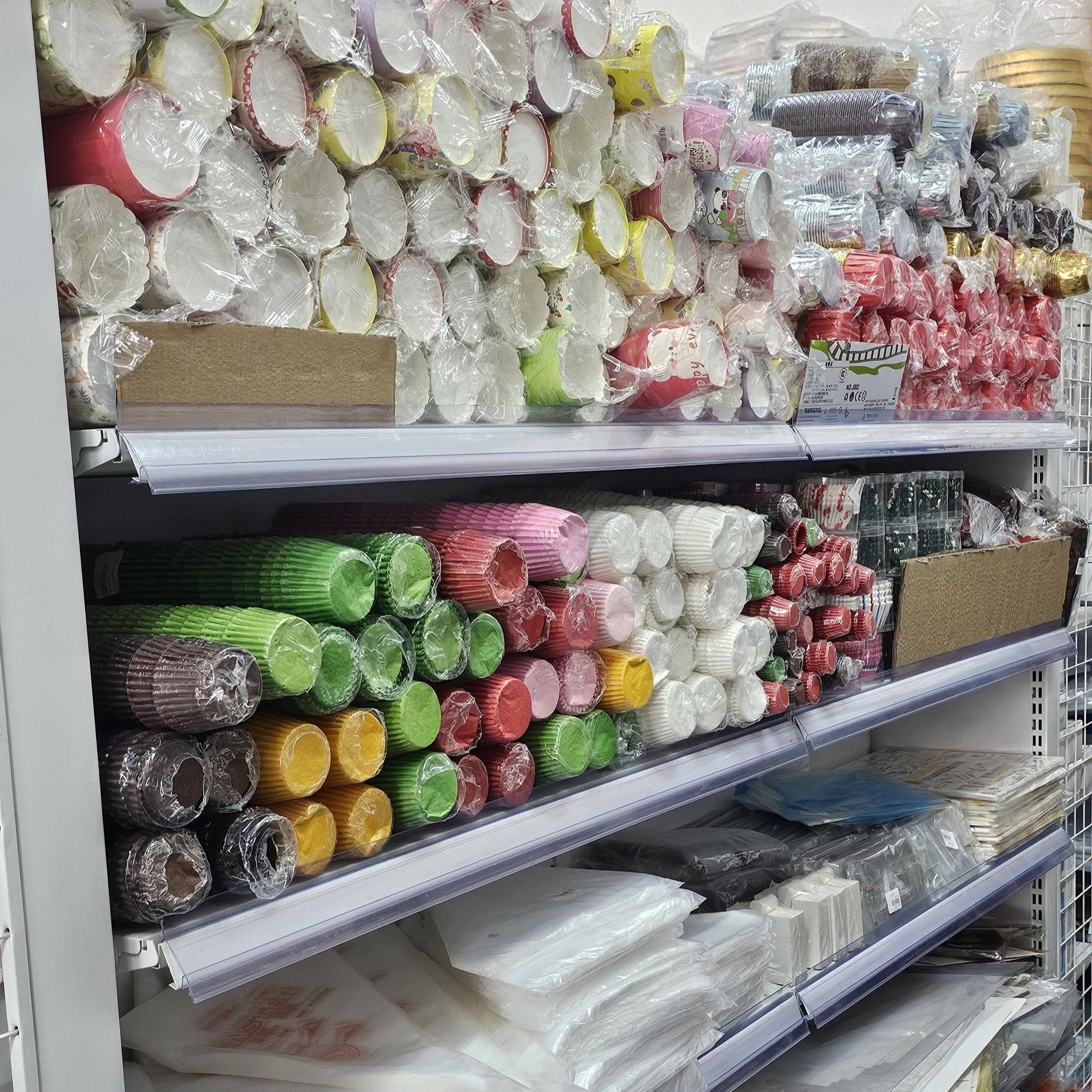 Shelves stacked with rolls of colourful cupcake and muffin paper liners