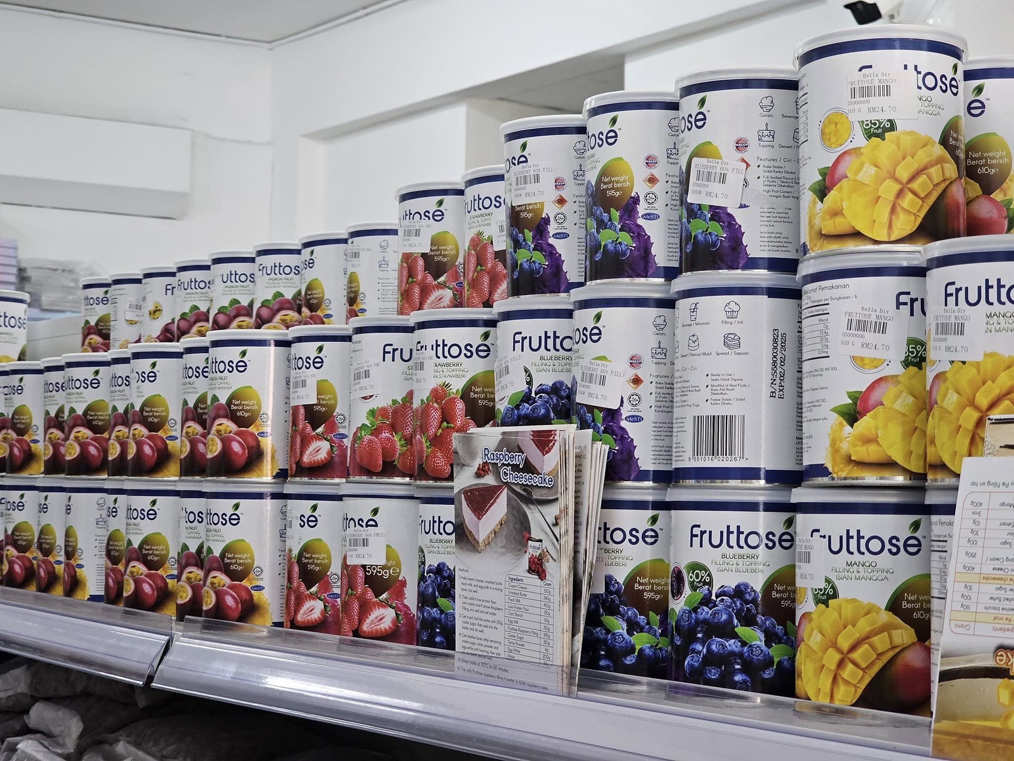 Rows of fruit filling and topping cans in blueberry, strawberry, mango and passion fruit